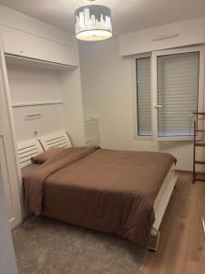 ビアリッツにあるLa Miladyのベッドとシャンデリアのある寝室