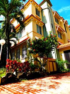 a yellow building with red flowers in front of it at Canario Boutique Hotel in San Juan