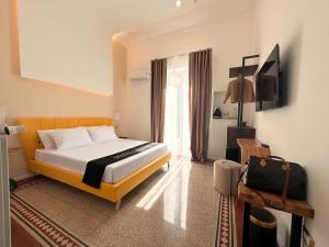 a bedroom with a bed and a television in it at Suites Cavour holiday dream in Palermo
