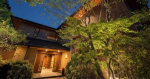 una casa de noche con un árbol en 箱根薫風, en Hakone 6 fotos más