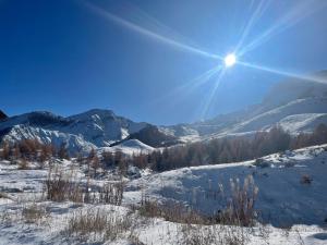 a snow covered mountain with the sun in the sky at Studio chaleureux 25m2 100m du centre 3-4 personnes in Vars