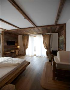 a bedroom with a bed and a desk in a room at Pineta Nature Resort - Wellness & SPA in Coredo