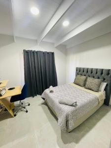 Un dormitorio con una cama y un escritorio. en 44 Staycation Beach-house, en Britannia Bay