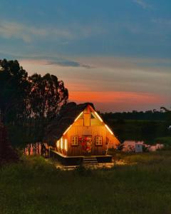 een houten huis met een rieten dak in een veld bij The Buddha Village in Chik Ballāpur