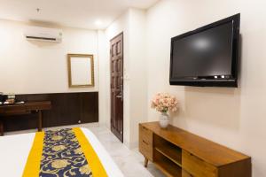 a bedroom with a large flat screen tv on the wall at Atana Saigon Boutique Hotel II in Ho Chi Minh City