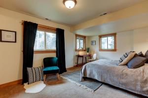 a bedroom with a bed and a chair and windows at The Bend House in Bend