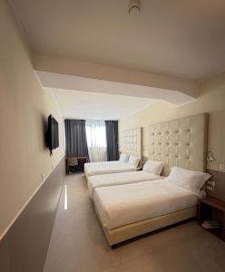 a hotel room with two beds and a television at Lh HOTELS in Milan