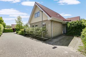 ein Backsteinhaus mit rotem Dach und Auffahrt in der Unterkunft Vakantiepark Schoorlse Duinen in Schoorl