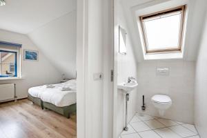 ein weißes Bad mit einem Bett und einem Waschbecken in der Unterkunft Vakantiepark Schoorlse Duinen in Schoorl + 63 Fotos