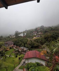 een klein dorpje op een heuvel met een mistige lucht bij Cabaña jenny in Tovar +11 foto's