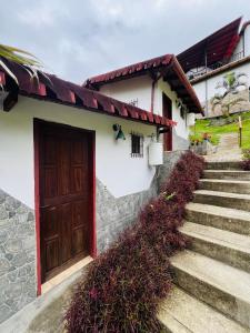 een huis met een houten deur en een trap bij Cabaña jenny in Tovar