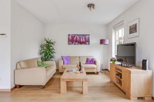 ein Wohnzimmer mit zwei Sofas und einem Fernseher in der Unterkunft Vakantiepark Schoorlse Duinen in Schoorl