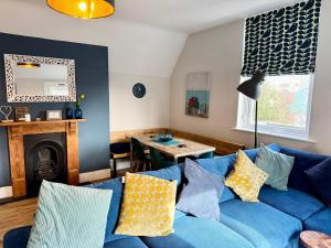 Una sala de estar con un sofá azul y una mesa. en St Helens House, en Portsmouth