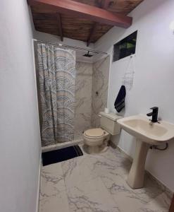 een badkamer met toilet en wastafel bij Cabaña jenny in Tovar