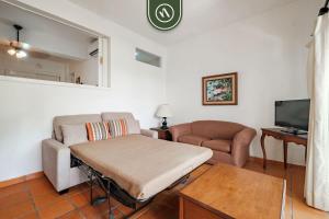 a living room with a couch and a tv at Amazing 2 BR Condo - Private Terrace - Pool in Puerto Vallarta