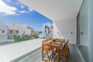 a table and chairs on a balcony with a view at CHL Naos del Mar, bright and modern apartment in Puerto Naos in Puerto Naos
