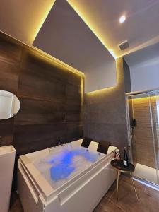 ein Badezimmer mit einer Badewanne mit blauem Wasser in der Unterkunft Suites Cavour holiday dream in Palermo