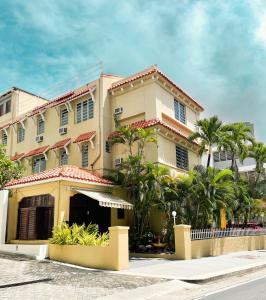 a large building with palm trees in front of it at Canario Boutique Hotel in San Juan