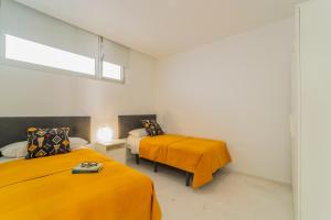 a room with two beds with orange sheets and a window at CHL Naos del Mar, bright and modern apartment in Puerto Naos in Puerto Naos +12 photos