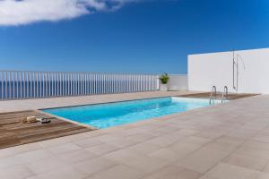 a swimming pool on the roof of a house at CHL Naos del Mar, bright and modern apartment in Puerto Naos in Puerto Naos