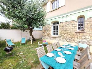 een blauwe tafel met borden in een tuin bij Villa Bellevue - Anglo-Norman seafront house in Ouistreham +43 foto's
