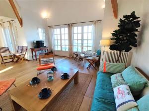 een woonkamer met een bank en een tafel bij Villa Bellevue - Anglo-Norman seafront house in Ouistreham