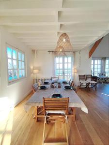 een grote eetkamer met een tafel en stoelen bij Villa Bellevue - Anglo-Norman seafront house in Ouistreham