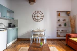a kitchen with a table and a clock on the wall at Le nid des rois - Terrasse en hyper centre in Blois +2 photos