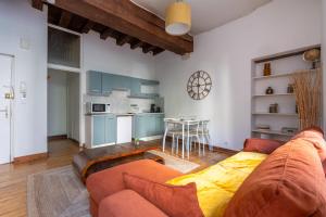 a living room with a couch and a table at Le nid des rois - Terrasse en hyper centre in Blois