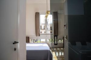 a bedroom with a white bed and a window at Suites Cavour holiday dream in Palermo
