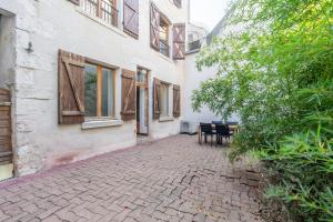 a brick walkway next to a building with a bench at Le nid des rois - Terrasse en hyper centre in Blois
