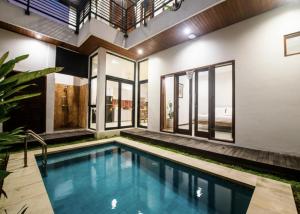 an indoor pool in a house with glass walls at Villa Richard 5mins to Seseh Beach in Munggu