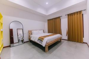 a bedroom with a large bed and a mirror at Villa Richard 5mins to Seseh Beach in Munggu