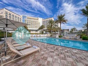 - Piscina en el complejo con tumbonas y sombrilla en Beach Resort Address Luxury 2BR with Maid Sea View, en Fujairah 8 fotos más