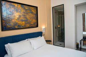 a bedroom with a bed and a painting on the wall at Suites Cavour holiday dream in Palermo +59 photos