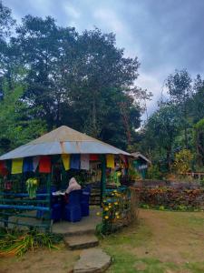 a person sitting at a table under an umbrella at Welcome homestay in Pemayangtse