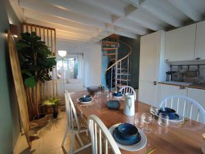 een eetkamer met een houten tafel en stoelen bij Cosy Villa by sea ! - two terraces in Ouistreham