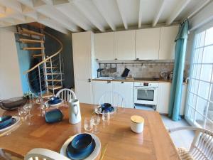 een keuken met een houten tafel met wijnglazen erop bij Cosy Villa by sea ! - two terraces in Ouistreham