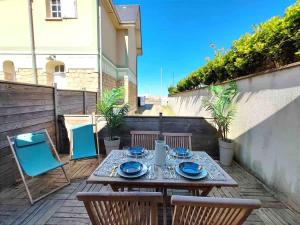 een houten tafel en stoelen op een terras bij Cosy Villa by sea ! - two terraces in Ouistreham +39 foto's