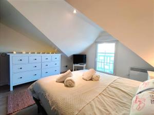 a bedroom with a bed with two towels on it at Cosy Villa by sea ! - two terraces in Ouistreham