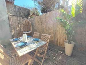 a table and chairs on a patio with a fence at Cosy Villa by sea ! - two terraces in Ouistreham