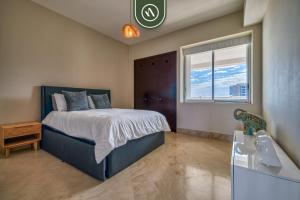 a bedroom with a bed and a sink and a window at Amazing 2BR Condo with Pool and Access to VIDANTA in Jarretadera +27 photos