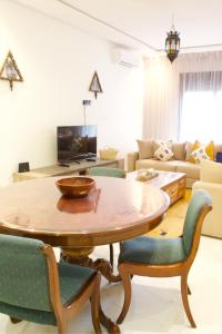 a living room with a wooden table and chairs at Azra Mila Appart luxe famille uniquement in Saidia 