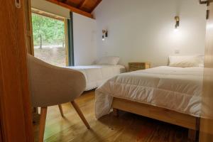 a bedroom with two beds and a window at Quinta da Fenteira - Casa Tora in Arcos de Valdevez