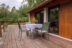 a patio with a table and chairs on a deck at Quinta da Fenteira - Casa Tora in Arcos de Valdevez