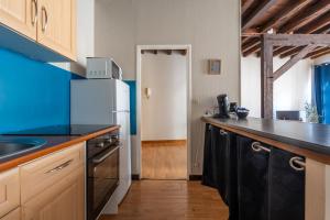 a kitchen with a black counter top and a refrigerator at L'escapade blésoise - Hyper Centre in Blois
