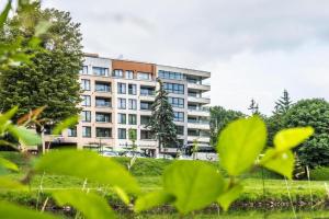 un edificio de fondo con plantas verdes en primer plano en Apartament Zagrodowa, en Oświęcim