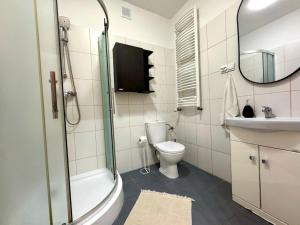 Un baño con inodoro, lavabo y ducha. en Apartament Zagrodowa, en Oświęcim 28 fotos más