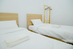Dos camas en una habitación con sábanas blancas. en B2 Romance Resort บีสแควร์ โรแมนซ์ รีสอร์ท, en Sathani Phu Khao Lat