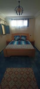 a bedroom with a large bed with a blue comforter at Dar Mobarak in Oualidia +6 photos